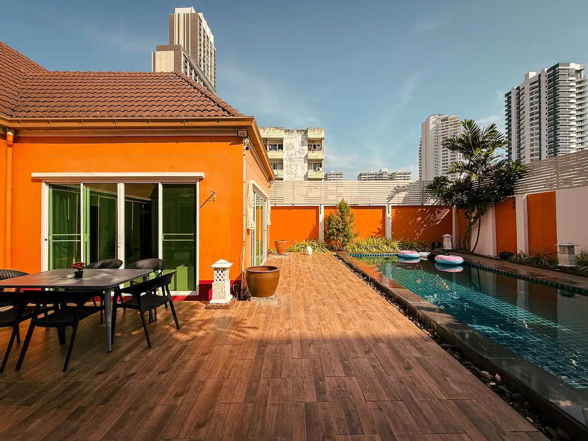 Wooden pool deck with outdoor dining at Magnitude Pool Villas